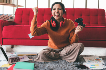a young woman is having fun playing games with a single joystick in the house. Social distancing during the COVID-19 epidemic. © amornchaijj