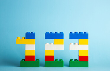 Color plastic building blocks on blue background