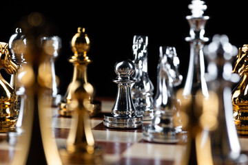 Gold and silver chess figures on chessboard