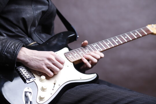 Dłonie gitarzysty na gryfie gitary elektrycznej
