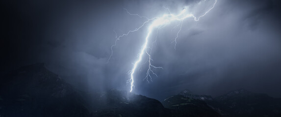 Lightning over mountains and lake. Switzerland.