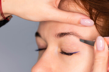 Young Caucasian Woman on the brow beauty procedures. Professional care for face. Brows coloring, wax and lamination. 