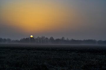 orange sunrise over agriculture fields a misty morning