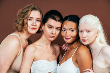 Obraz premium Group of multiethnic women with different kind of skin posing together in studio. Concept about body positivity and self acceptance