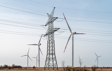 Power mast with wind farm in background