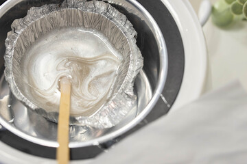 Wax for brow epilation prepare. Hot wax in machine. Professional care for face and brow beauty procedures. 
