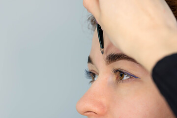 Fototapeta premium Young Caucasian Woman on the brow beauty procedures. Professional care for face. Brows coloring, wax and lamination. 