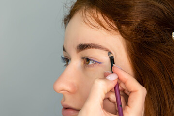 Young Caucasian Woman on the brow beauty procedures. Professional care for face. Brows coloring, wax and lamination. 