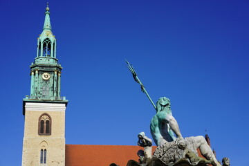 Teilaufnahme Neptunbrunnen und Marienkirche in Berlin am Alexanderplatz bei Sonnenschein und blauem...