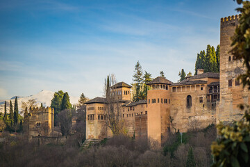 View at sunset on the Alcazaba, the medieval fortress part of the Alhambra complex in Granada, Andalusia, Spain, with the Sierra Nevada mountains in the background