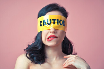 Cinematic image of a woman with a yellow tape on her face. Abstract fine art concept