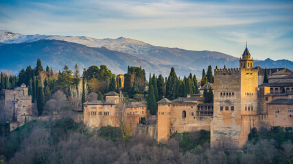 Fototapeta na wymiar View at sunset on the Alcazaba, the medieval fortress part of the Alhambra complex in Granada, Andalusia, Spain, with the Sierra Nevada mountains in the background