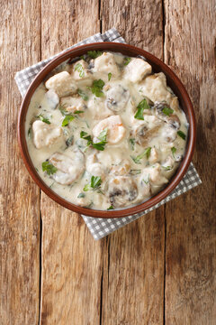 Romanian Creamed Chicken Ciulama de pui closeup in the bowl on the table. Vertical top view from above