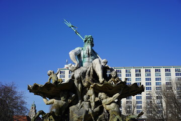 Der Neptunbrunnen am Alexanderplatz in Berlin bei Sonnenschein und blauem Himmel