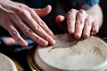 closeup male hands playing bongo