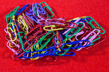 Heart of colored paper clips on a bright red background