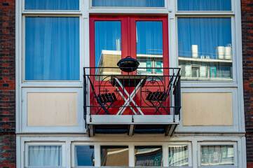 Typical Dutch window frame and balcony with two chairs, table and barbeque facility