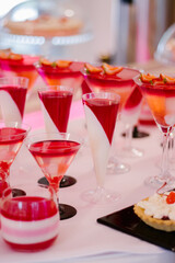 Wedding candy bar full of red and white desserts on a white table