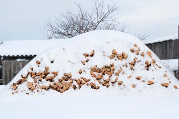 winter, a pile of firewood littered with snow
