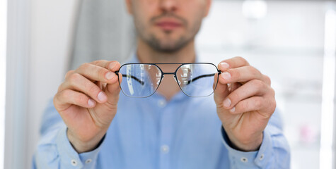 Fototapeta premium Closeup portrait of man showing spectacles to camera