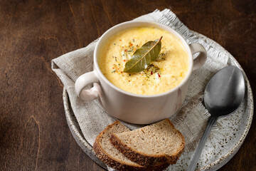 The cream of chicken soup. Puree soup chicken, carrot and onion soup with cream. Chicken soup in a bowl on a brown wooden table