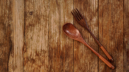 Wooden spoon and fork on wooden background. Asian style wooden appliances. Copy space