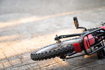 Close up of bicycle falling on the ground under sunlight. Selective focus on Hex nut. Accident and bike safety. Learning to bike bicycle. No people. Rust on the back wheel..