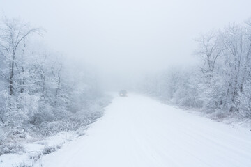 Obraz na płótnie Canvas Car on snowy road in winter forest
