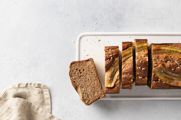 Sliced vegan buckwheat banana bread on white board. Healthy vegan dessert. place for text. top view