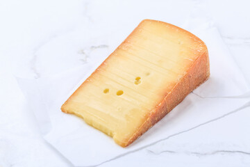 Piece of hard cheese on white paper