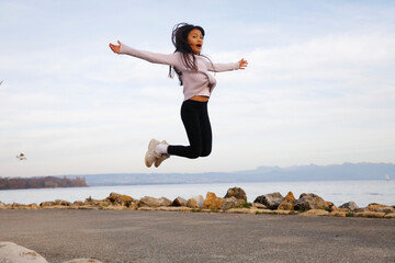 Jolie jeune fille asiatique saute au bord du lac