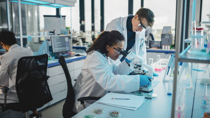 Obraz premium Modern Medicine Laboratory: Diverse Team of Multi-Ethnic Young Scientists Analysing Test Samples. Advanced Lab with High-Tech Equipment, Microbiology Researchers Design, Develop Drugs, Doing Research