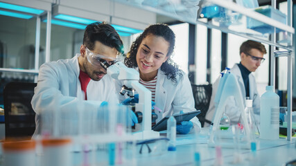 Modern Medical Research Laboratory: Portrait of Latin and Black Young Scientists Using Microscope,...