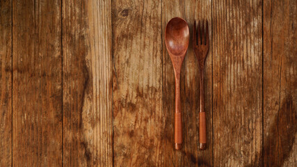 Wooden spoon and fork on wooden background. Asian style wooden appliances. Copy space