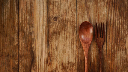 Wooden spoon and fork on wooden background. Asian style wooden appliances. Copy space