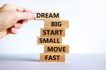 Dream big start small symbol. Words 'dream big start small move fast' on wooden blocks on a beautiful white background. Businessman hand. Business, motivational and dream big start small concept.