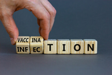 Vaccination vs infection symbol. Doctor turns wooden cubes and changes the word 'infection' to 'vaccination'. Beautiful grey background. Medical and vaccination vs infection concept. Copy space.