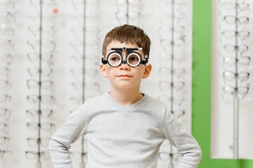 Boy put trial frame at clinic Medical Optician concept.