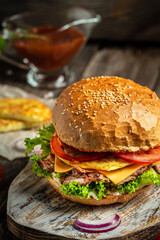 Close-up of tasty homemade burger on rustic wooden background. fast food and junk food concept
