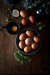 Fresh uncooked eggs in rustic bowl on natural wooden background. Raw chicken eggs on the wooden background.