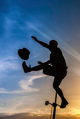 Silhouette of an equilibrist riding an unicycle, making some juggling with a top-hat © nicolas