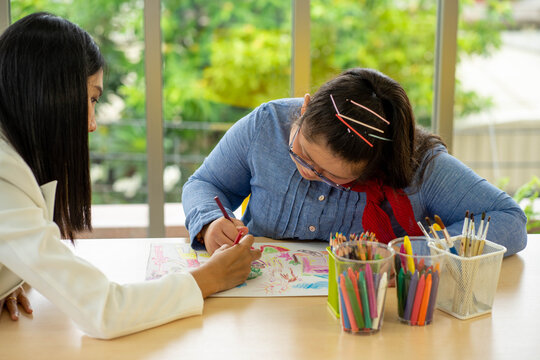 Asian Autism girl playing and learning in special school with young teacher