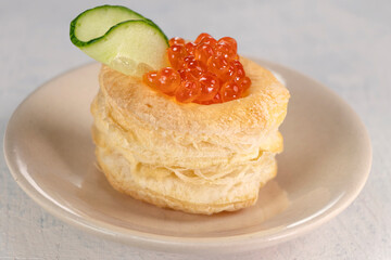Appetizer with red caviar. Tartlets, red caviar, cucumber on a white background. Delicious and healthy snack.