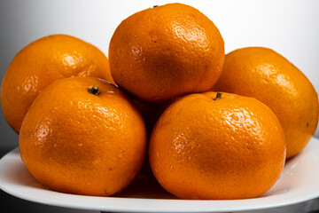 tangerines on a white plate on a white or yellow background