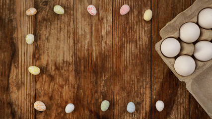 Chicken eggs in a cardboard tray and Easter decor on a wooden background., Rural Style. Frame with place for text