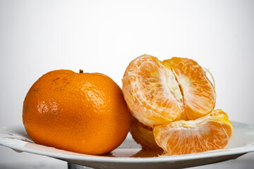 tangerines on a white plate on a white or yellow background