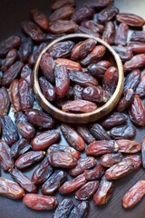 organic fresh dates. Inside the wooden plate and blurred background