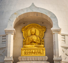 Budhha praying golden statue isolated in details from unique perspective