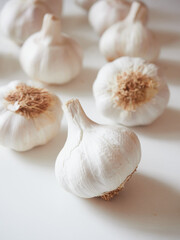 Whole garlic bulbs on a light background. One closeup one garlic bulb and others out of focus