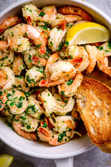 Lemon garlic butter srimp in a white frying pan.top view